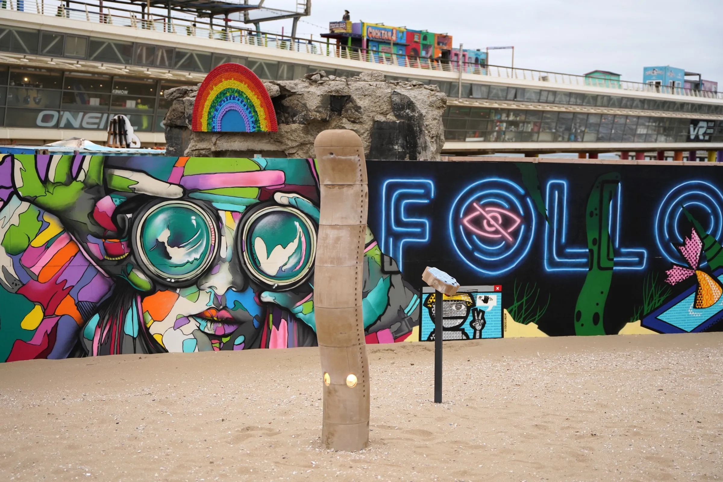 The Wave in daylight, showing the segmented sand-printed form against the beach murals